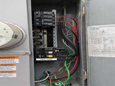 "Licensed electrician installing 50-amp double-pole breaker for heat pump circuit in Sunnyvale home"