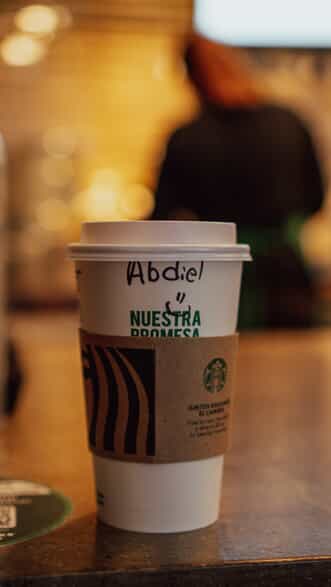 : a take out Starbucks cup with the name Abdiel written on it