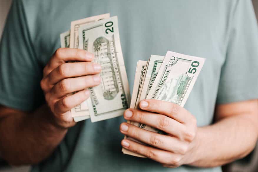  a close up of a man counting 20 dollar bills